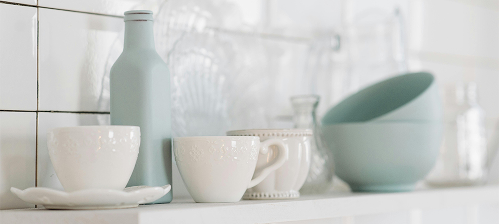 Add Charm to Small Kitchens with Decorative Dishware A small kitchen featuring open shelves displaying decorative dishware and collectibles