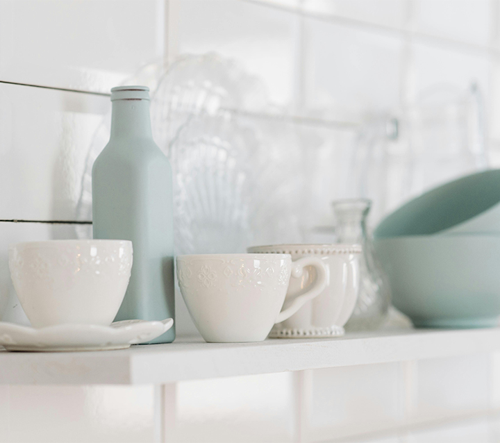 Add Charm to Small Kitchens with Decorative Dishware A small kitchen featuring open shelves displaying decorative dishware and collectibles