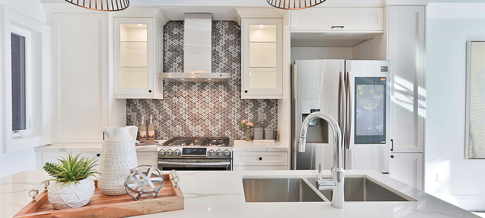 Modern white kitchen featuring a stylish ceramic backsplash with intricate patterns, white cabinetry, and stainless steel appliances.