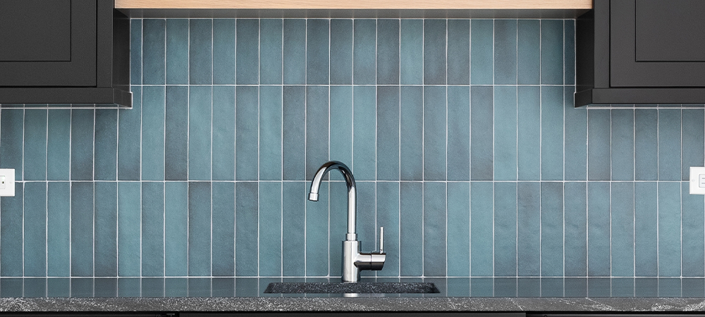 Vertical Glass Tile Backsplash in Teal with Modern Chrome Faucet Modern teal glass tile backsplash installed vertically with chrome faucet and gray granite countertop in contemporary kitchen