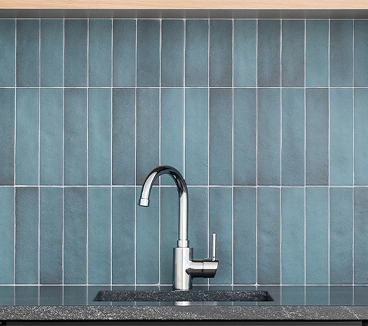 Vertical Glass Tile Backsplash in Teal with Modern Chrome Faucet Modern teal glass tile backsplash installed vertically with chrome faucet and gray granite countertop in contemporary kitchen