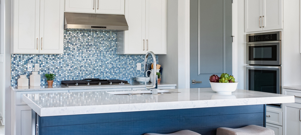 A modern kitchen with white cabinets and a blue kitchen island, creating a bold and stylish contrast.