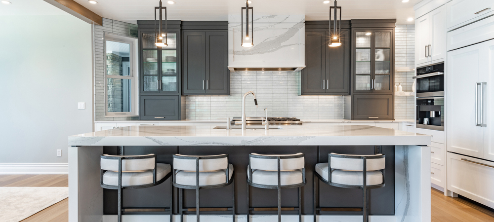 Two-Tone Kitchen with Glass-Front Cabinets A modern kitchen with dark gray cabinets, featuring glass-front cabinets for a stylish and functional look.