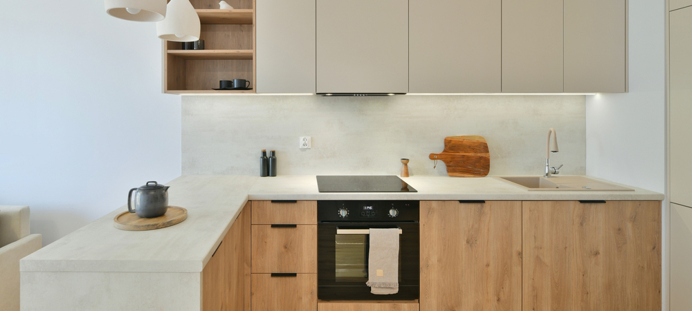 Modern kitchen with light gray cabinets and wood accents, creating a warm and inviting atmosphere.