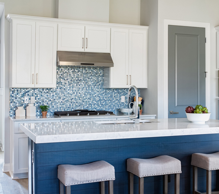 A modern kitchen with white cabinets and a blue kitchen island, creating a bold and stylish contrast.