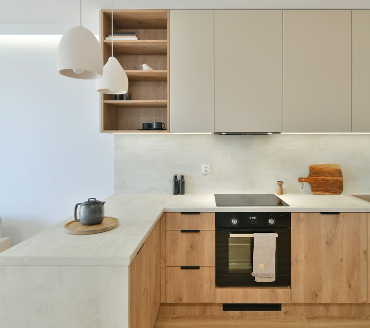 Modern kitchen with light gray cabinets and wood accents, creating a warm and inviting atmosphere.